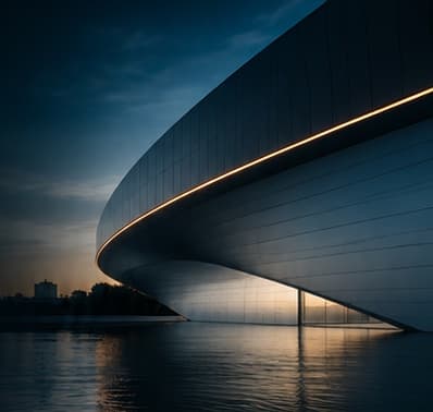 Modern curved building at dusk with a warm strip of light, reflected in still water